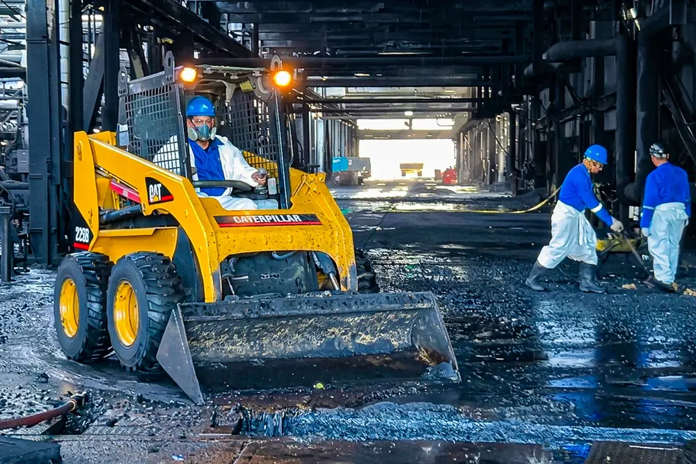 Minicargadora retirando lodos dentro de una nave