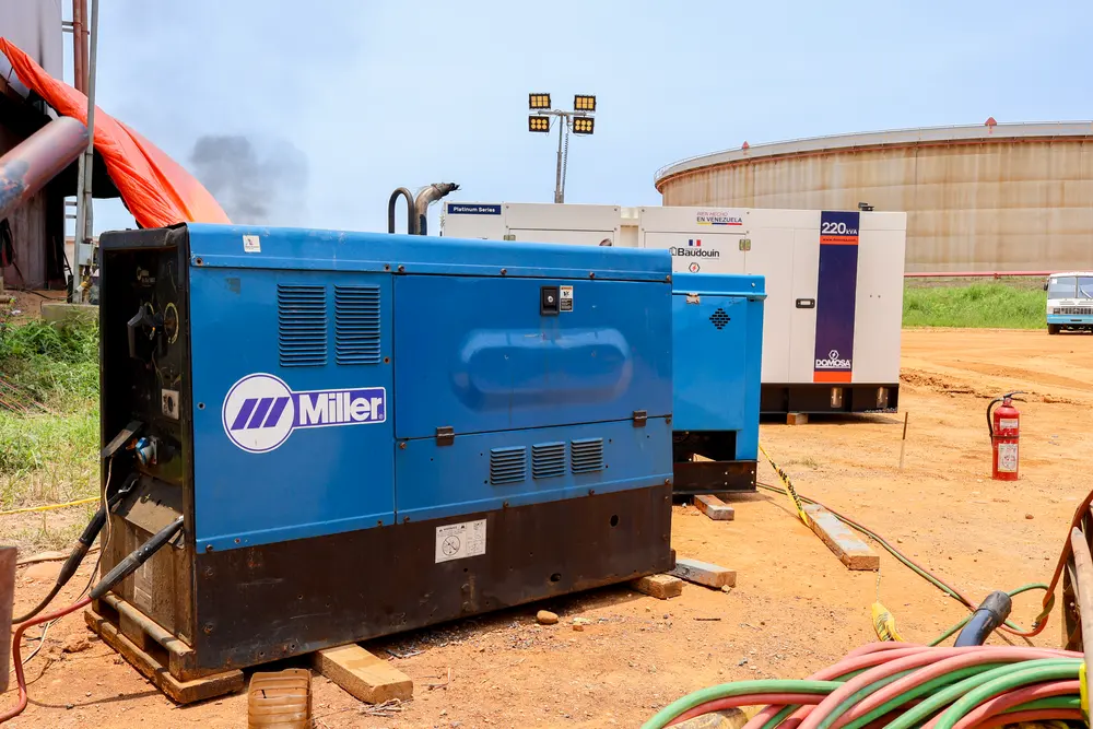 Máquina de soldar en operación junto al patio de tanques