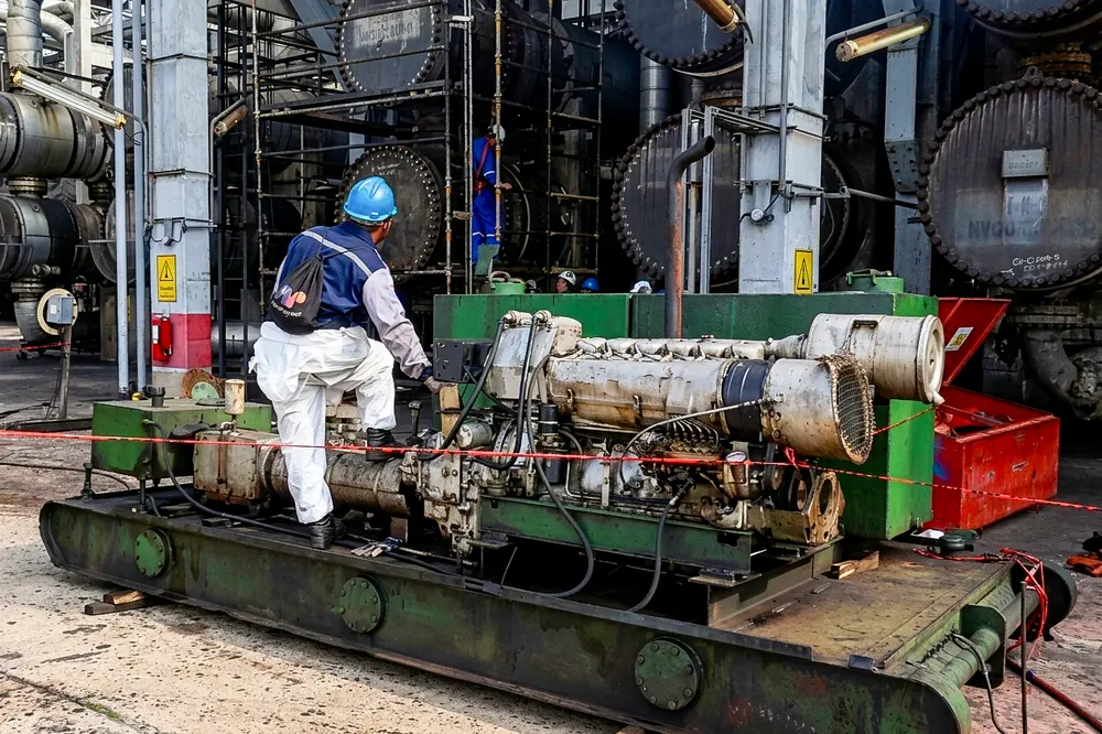 Técnico interviniendo un motor de combustión montado sobre skid