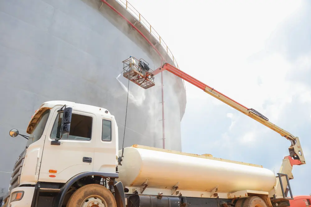 Camión cisterna con brazo hidráulico durante los trabajos en el tanque